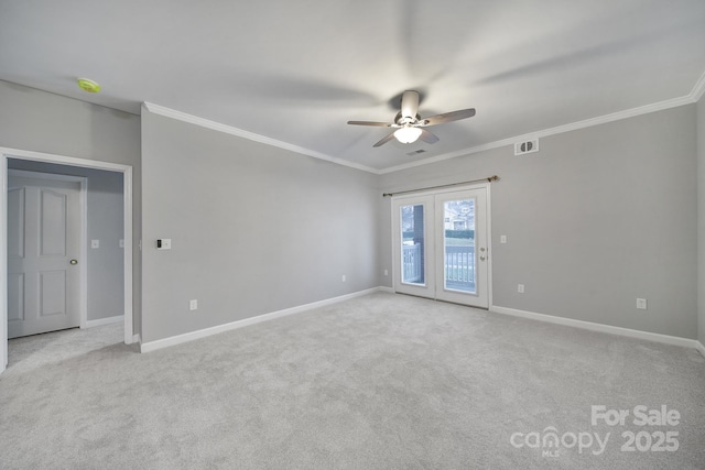 spare room featuring baseboards, ornamental molding, visible vents, and light colored carpet