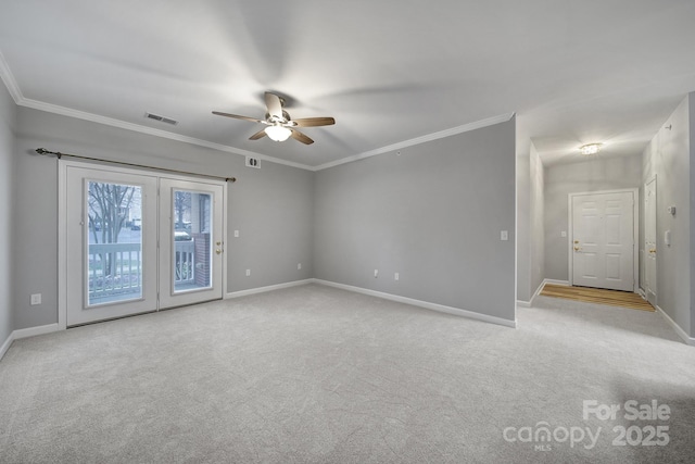 empty room featuring visible vents, crown molding, light carpet, and baseboards