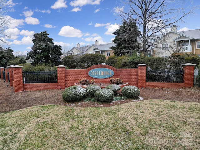 community / neighborhood sign with a residential view, fence, and a yard