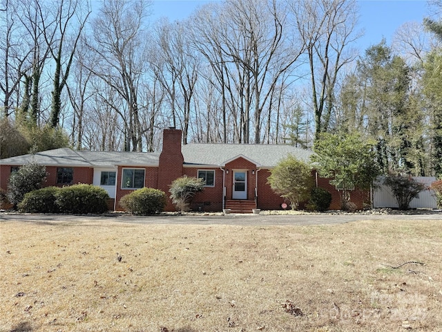 ranch-style home featuring a front yard, brick siding, and a chimney