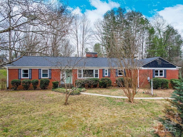 ranch-style house with a front lawn, a chimney, and brick siding