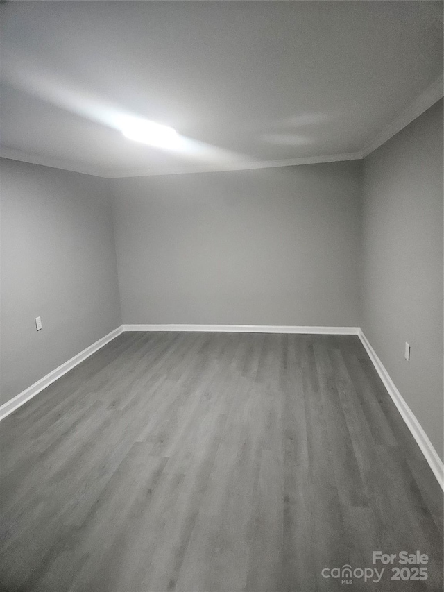 unfurnished room with dark wood-style floors and baseboards