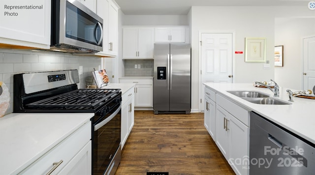 kitchen with stainless steel appliances, light countertops, and white cabinetry