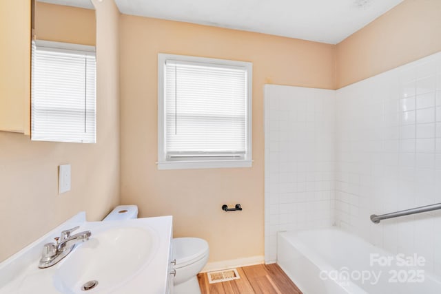 full bath with plenty of natural light, visible vents, a sink, and wood finished floors