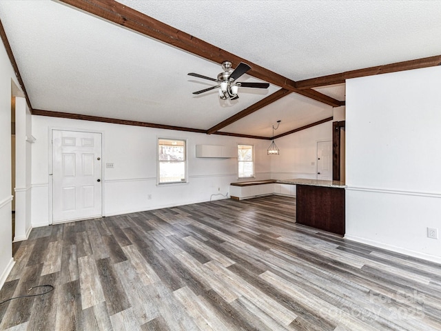 unfurnished living room featuring baseboards, a ceiling fan, wood finished floors, vaulted ceiling with beams, and a textured ceiling