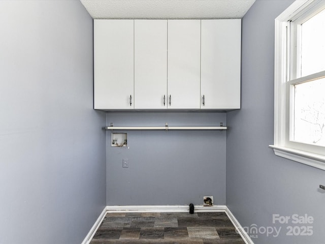 washroom with hookup for a washing machine, dark wood-style flooring, cabinet space, and baseboards