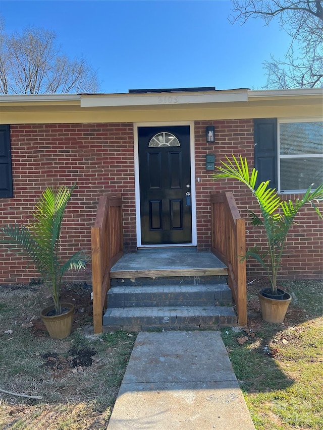 property entrance featuring brick siding