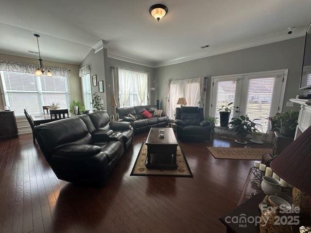 living room with a healthy amount of sunlight, crown molding, and dark wood-type flooring