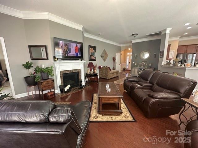 living area featuring dark wood-style floors, baseboards, a premium fireplace, and ornamental molding