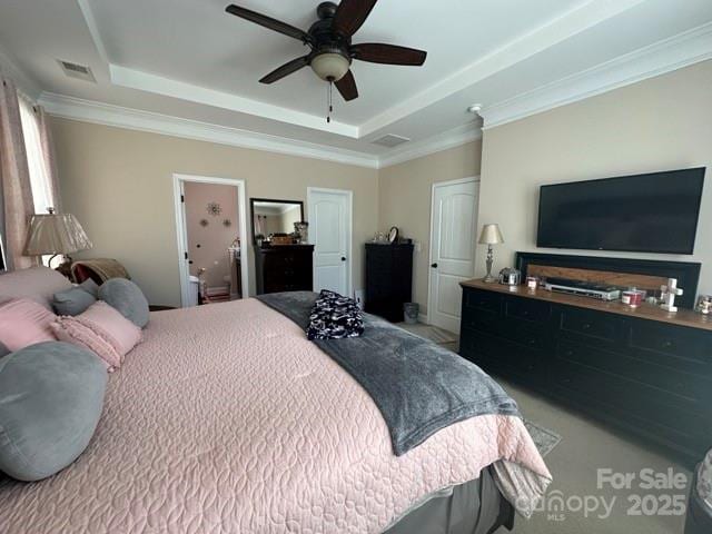 bedroom featuring ornamental molding, a raised ceiling, and a ceiling fan