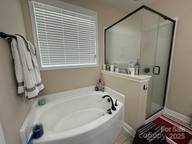 full bathroom featuring a stall shower, a garden tub, and tile patterned floors