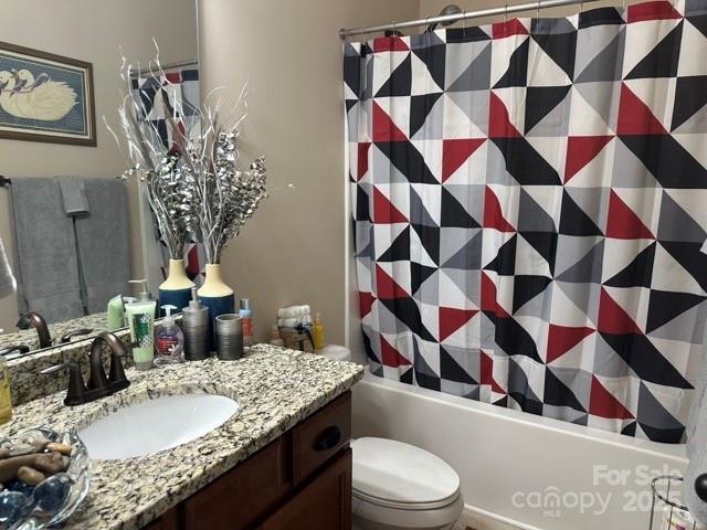 bathroom with shower / tub combo, vanity, and toilet