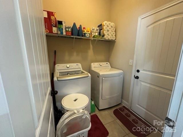 washroom with washer and dryer, laundry area, and light tile patterned floors