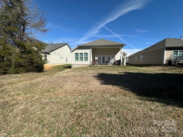 rear view of property featuring a yard