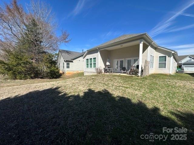 rear view of property featuring a yard