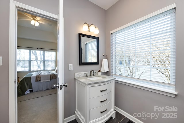 ensuite bathroom featuring baseboards, ensuite bathroom, a ceiling fan, and vanity