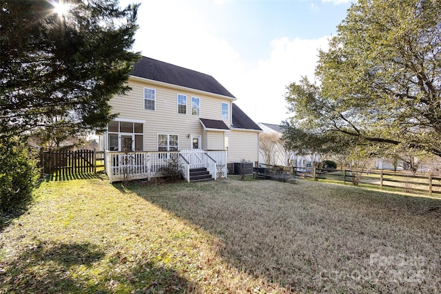 back of house featuring a deck, a yard, and a fenced backyard