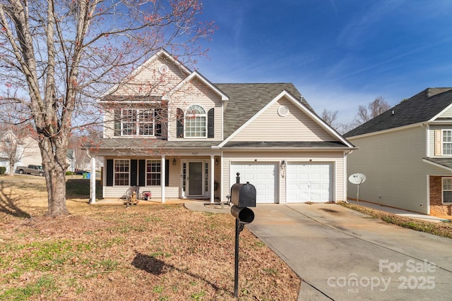 traditional-style house featuring concrete driveway, a porch, and an attached garage