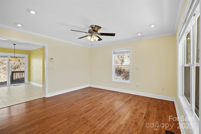 unfurnished room with ornamental molding, light wood-style flooring, and baseboards