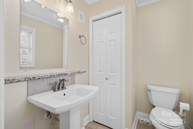 half bathroom with toilet, ornamental molding, backsplash, and a closet