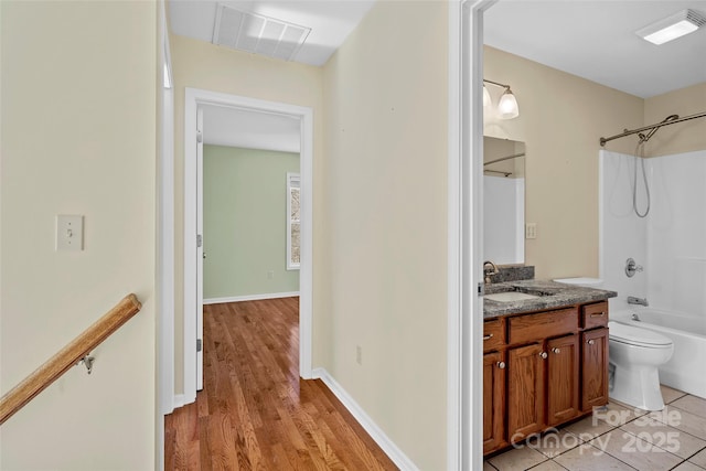 bathroom with visible vents, toilet, vanity, and shower / tub combination