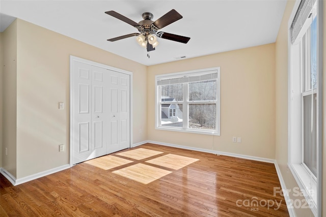 unfurnished bedroom featuring a closet, baseboards, and wood finished floors