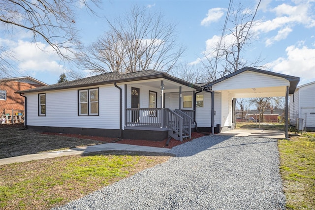 single story home featuring a porch, driveway, crawl space, a carport, and a front yard