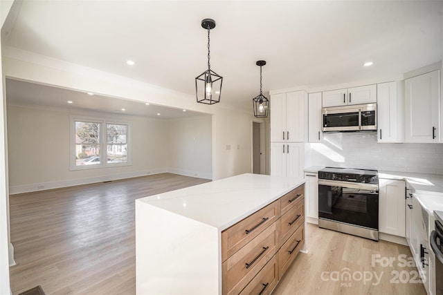 kitchen featuring a center island, appliances with stainless steel finishes, white cabinets, and pendant lighting