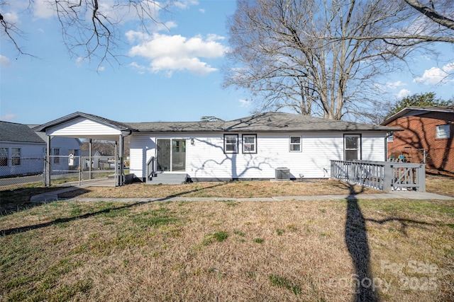 back of house featuring a carport, central AC, a yard, and fence