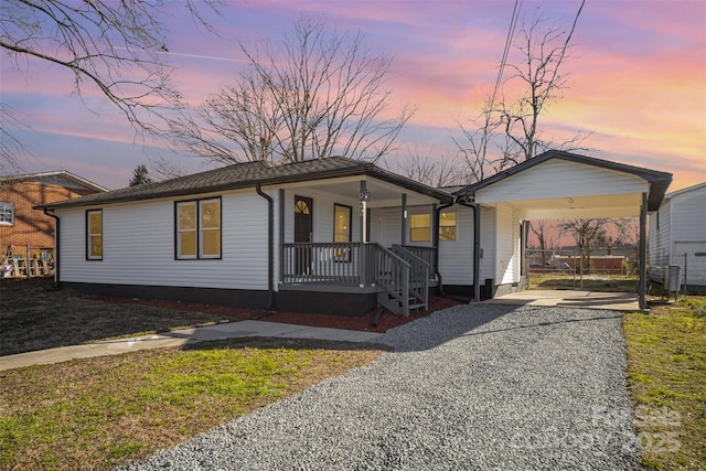 ranch-style house with a porch, gravel driveway, and crawl space