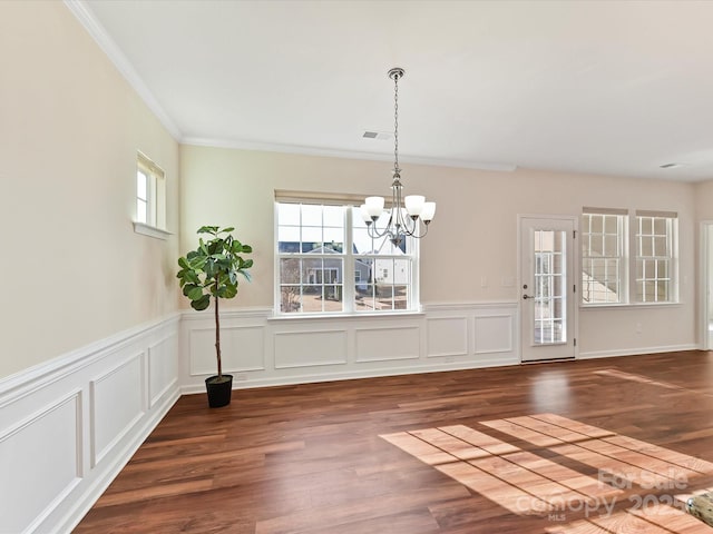 unfurnished dining area with crown molding, visible vents, dark wood-type flooring, and a notable chandelier