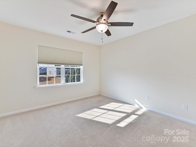 unfurnished room featuring light carpet, a ceiling fan, visible vents, and baseboards