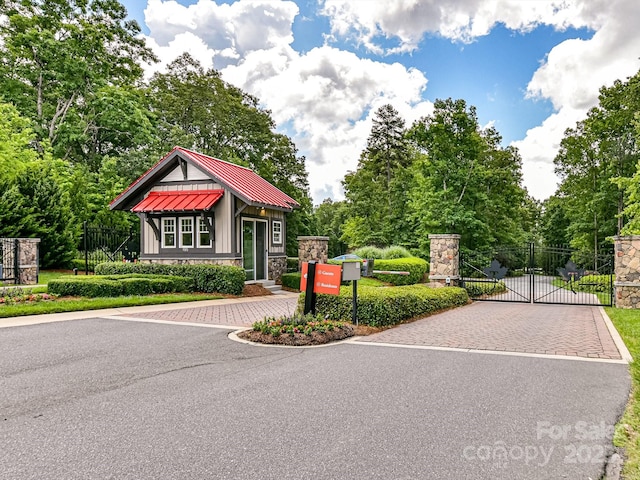 exterior space with aphalt driveway, fence, and a gate