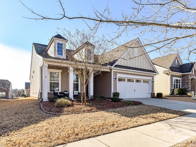 view of front of house featuring driveway, covered porch, an attached garage, and board and batten siding