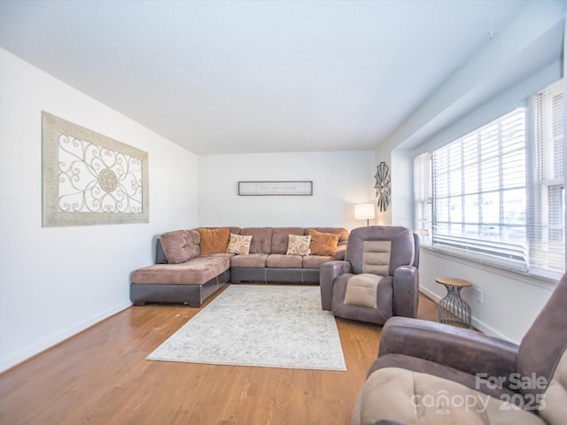 living area with baseboards and wood finished floors