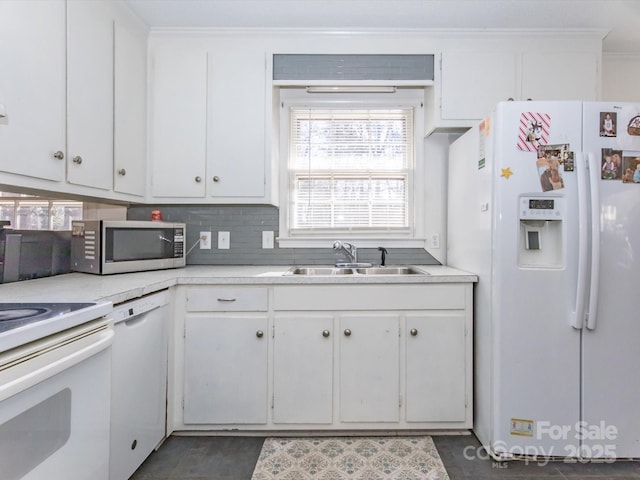 kitchen featuring white cabinets, white appliances, light countertops, and a sink