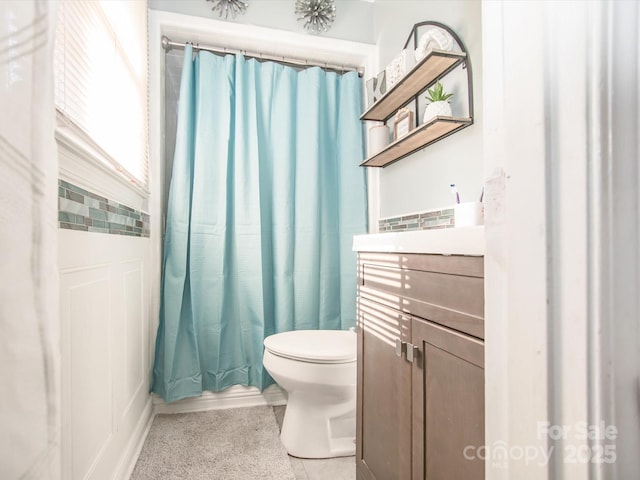 full bathroom with a shower with shower curtain, vanity, and toilet