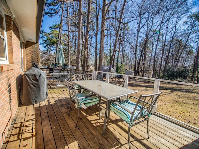 deck with a grill and outdoor dining space