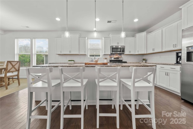 kitchen with dark wood-style floors, white cabinetry, and appliances with stainless steel finishes