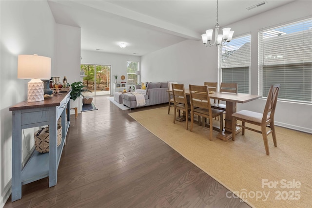 dining space featuring a chandelier, wood finished floors, visible vents, and baseboards