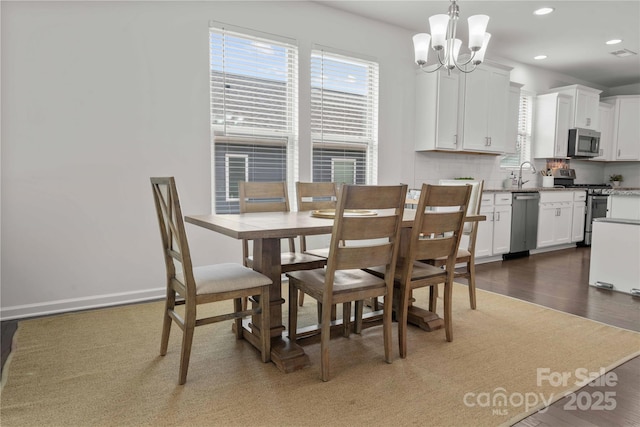 dining area with a notable chandelier, baseboards, wood finished floors, and recessed lighting