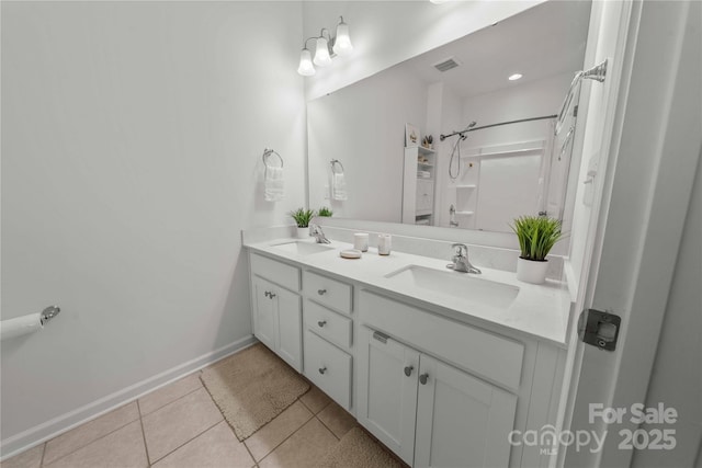 bathroom with double vanity, visible vents, a sink, and tile patterned floors