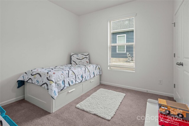 bedroom featuring carpet and baseboards