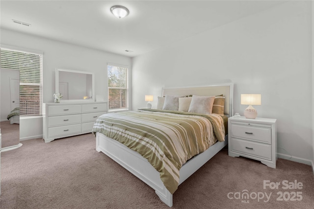 carpeted bedroom with visible vents and baseboards