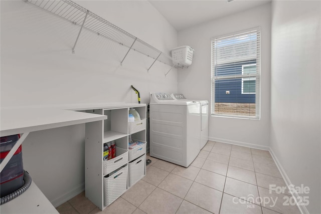 laundry room with laundry area, light tile patterned floors, baseboards, and separate washer and dryer