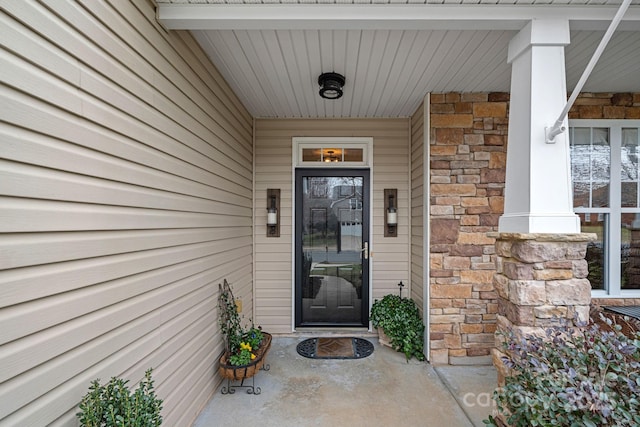 property entrance featuring stone siding and a porch