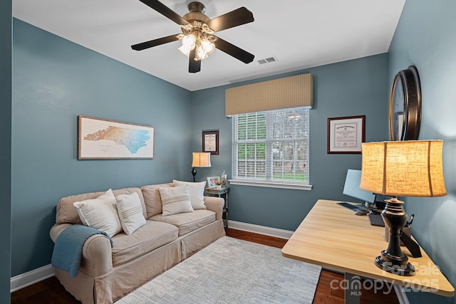 office area with baseboards, visible vents, ceiling fan, and wood finished floors