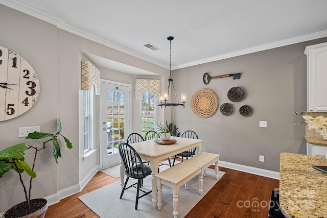 dining space featuring ornamental molding, visible vents, and dark wood finished floors