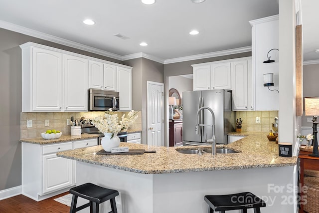 kitchen featuring stainless steel appliances, visible vents, a peninsula, and a kitchen breakfast bar