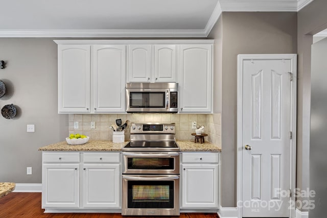 kitchen with stainless steel appliances, backsplash, white cabinetry, and light stone countertops